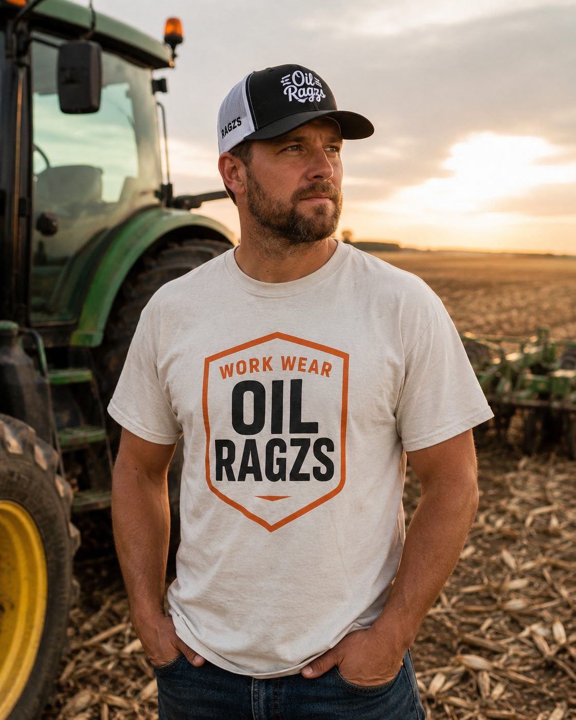 Man wearing Oil Ragzs tee in front of a tractor at sunset