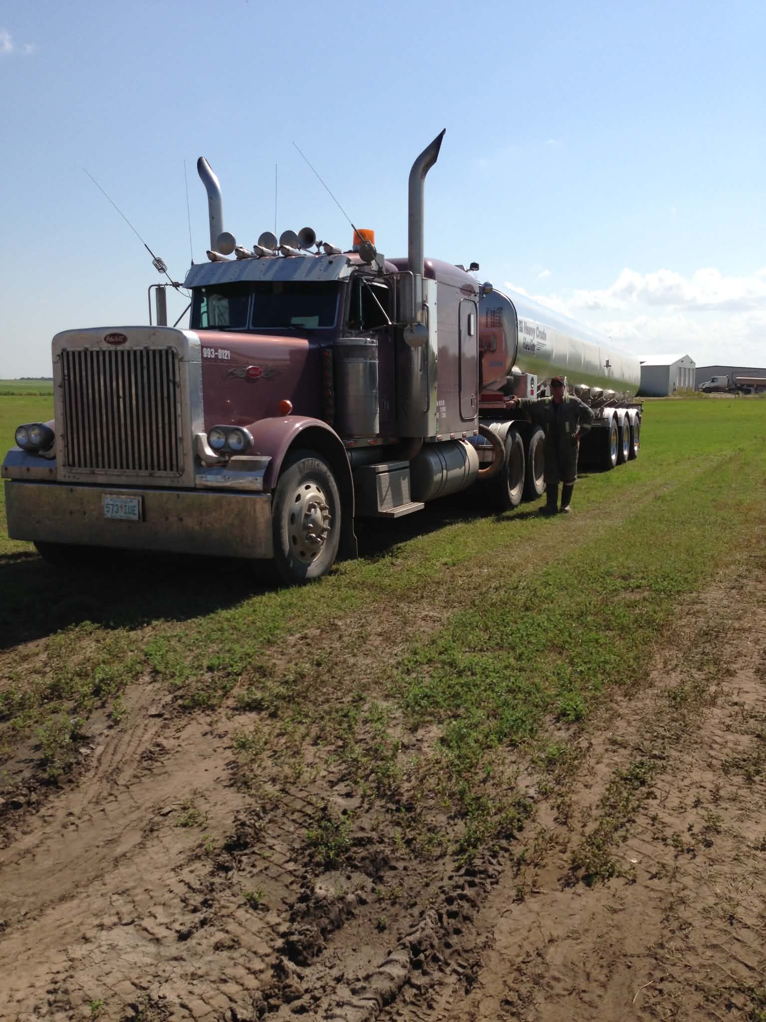 Crude oil hauling truck and trailer parked in a field