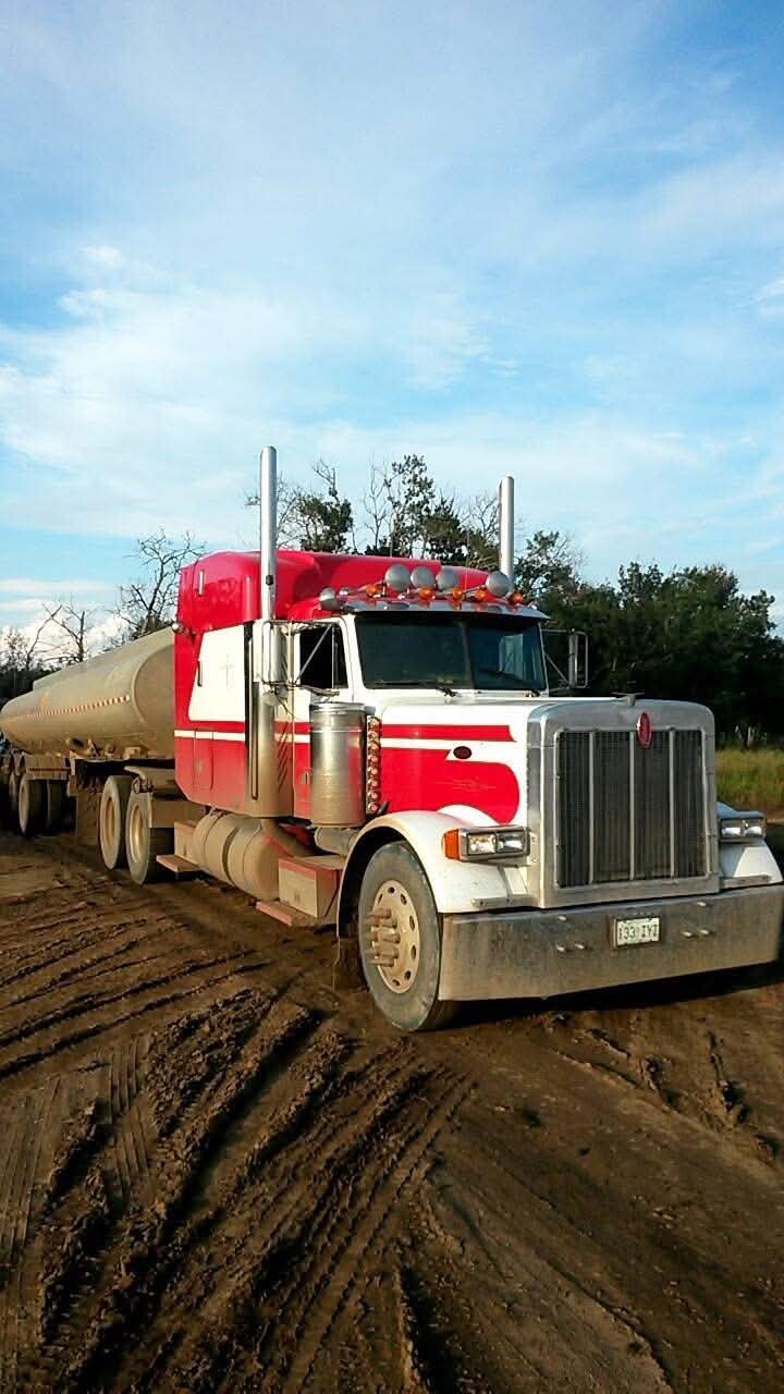 Red and white crude oil hauling truck